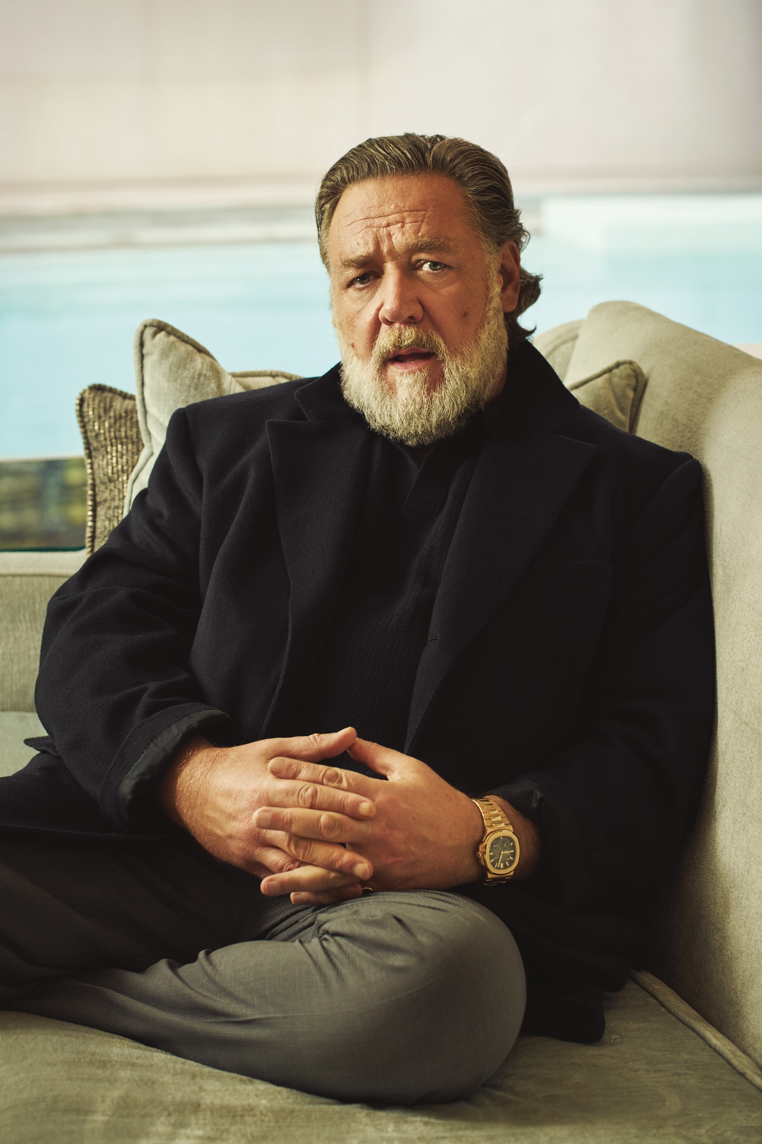 Brunico cashmere coat, Brioni; open-collar cashmere jumper, Private White V.C.; grey trousers, Dior; 5712 Nautilus in rose gold, Patek Philippe; ring, Russell’s own.